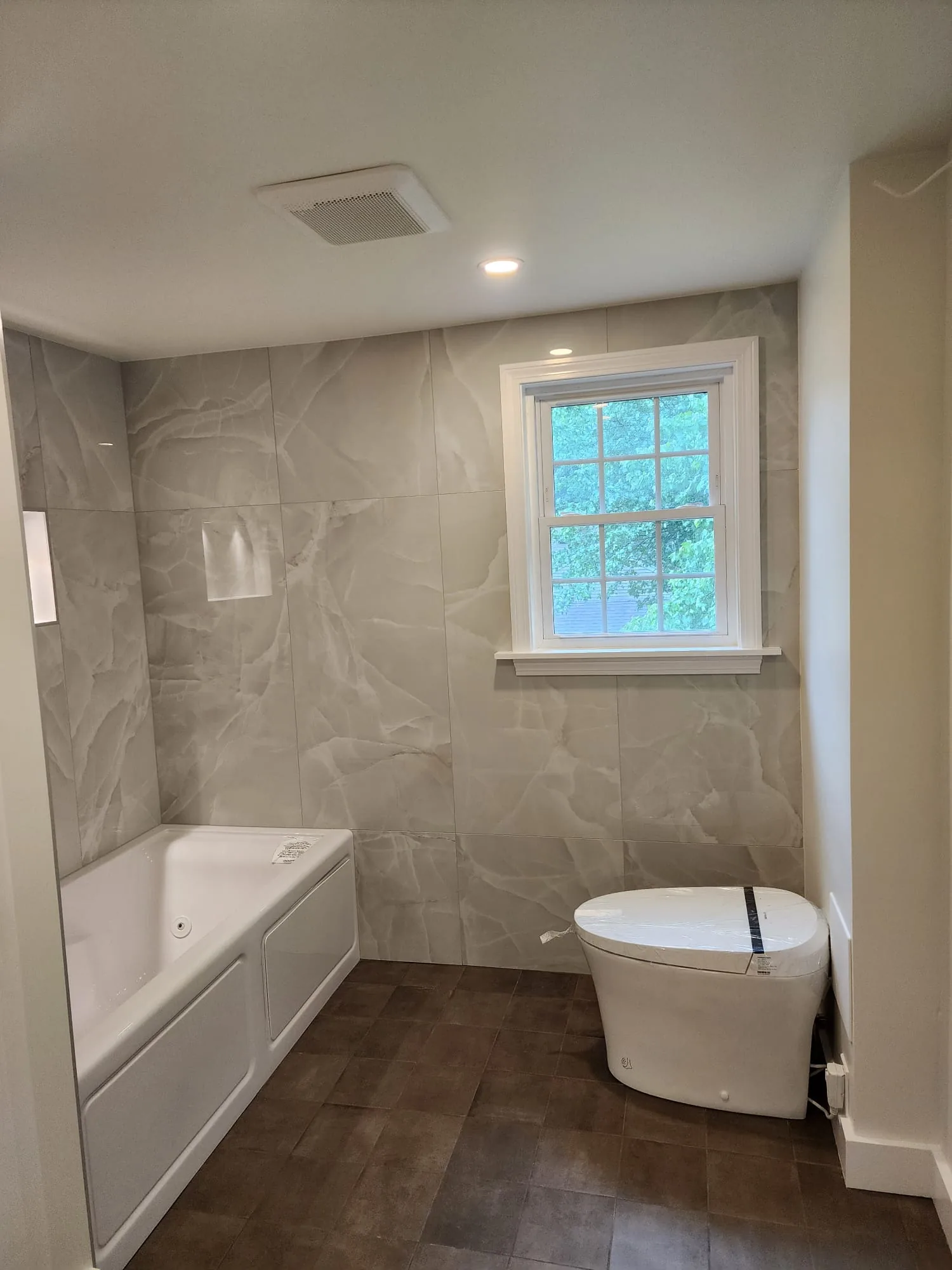 Bathroom with large-format wall tile and wood-look floor