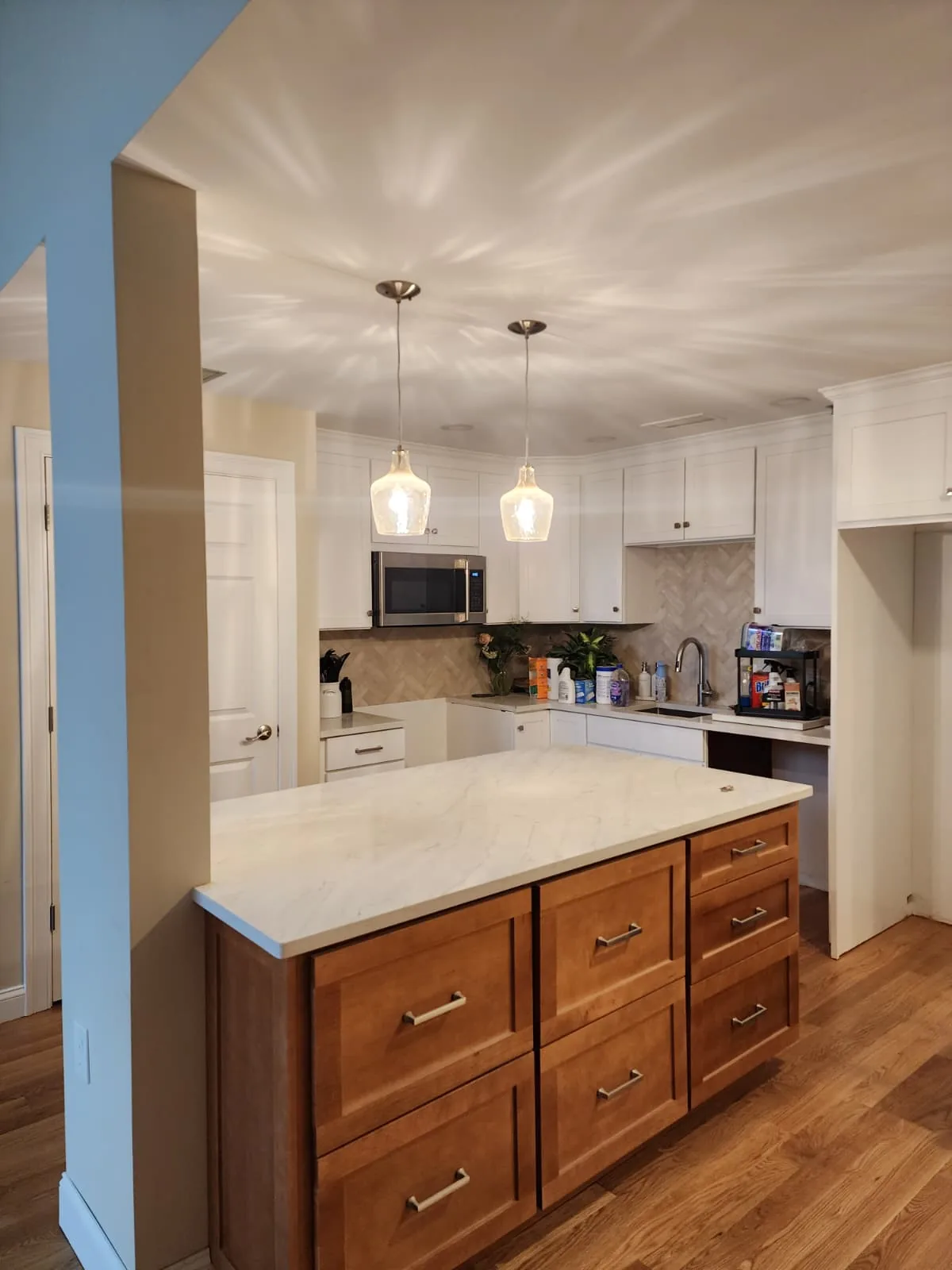 Kitchen island with wood cabinetry and a finished wood floor