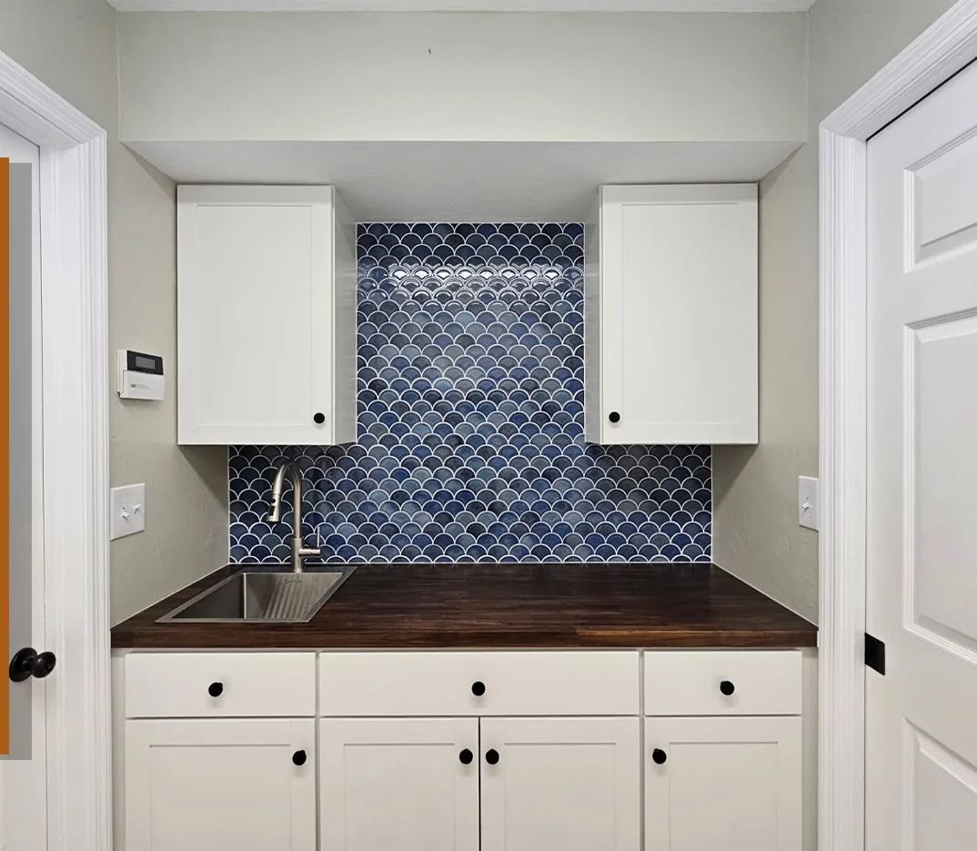 White cabinets with a blue fish-scale tile backsplash