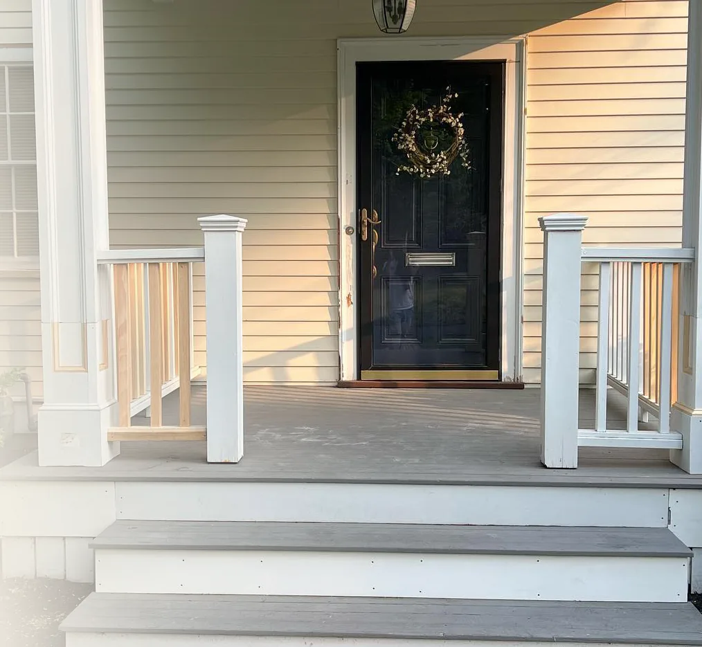 Front porch with new steps, white posts and railing
